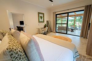 侯斯普瑞特Nomads Den Luxury Villa with Riverbed View的一间卧室配有一张床,享有庭院的景色