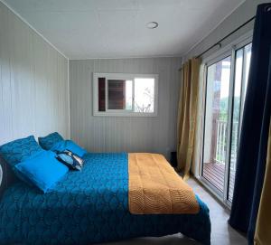 圣若瑟Anaïs Pool的一间卧室设有蓝色的床和窗户。