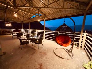 穆索里The Four Season Resort - Top Rated & Most Awarded Property in Mussoorie的一个带桌椅和吊床的庭院