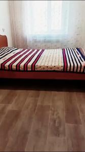 巴甫洛达尔3-х комнатная квартира в Павлодаре的一张位于带窗户的房间的床
