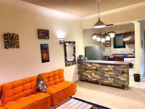 拉斯苏德尔Furnished Chalet Apartment at La Hacienda Ras Sedr的客厅里配有橙色沙发,设有厨房