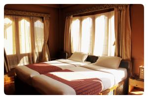 帕罗Hotel Jigmeling的配有窗户的客房内的两张床