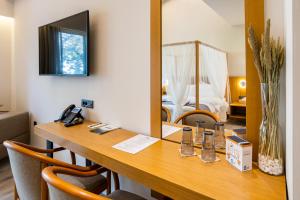 ArtemisíaDenthis Hotel - Taygetos Mountain Getaway的客房设有一张带镜子的书桌和一张床
