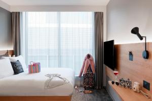 曼彻斯特Moxy Manchester City的酒店客房设有一张床和一个大窗户