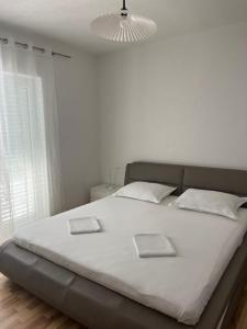格拉达茨Apartment Davor的卧室内的一张白色床和两本书