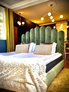 格兰纳格雷纳酒店的一间卧室配有一张大床和绿色床头板