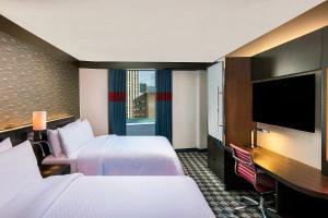 纽约纽约市区福朋喜来登酒店的酒店客房设有两张床和一台平面电视。