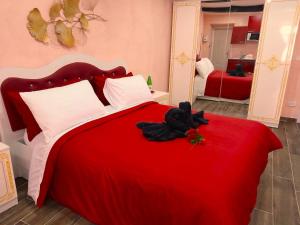 菲乌吉IL NIDO Suite的一间卧室,配有一张红色的床,上面有黑泰迪熊