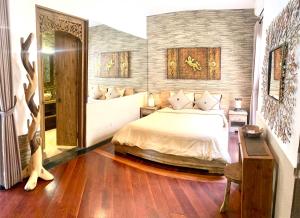 坎古新奇巴厘岛别墅住宿加早餐旅馆的一间卧室配有一张床和一张桌子及椅子