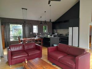 SpringfieldSpringfield Retreat的一间带两张红色沙发的客厅和一间厨房