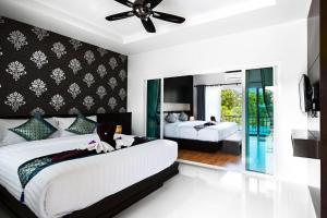 高兰Phutara Lanta Resort - SHA Extra Plus Koh Lanta的一间卧室配有两张床和吊扇