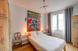 图尔Chic et Cosy - 5mn de la gare - Arrivée Autonome的卧室配有一张床,墙上挂有绘画作品