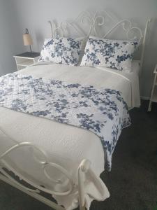 上哈特Mangaroa, farmstay的白色的床,配有蓝色和白色的床单和枕头