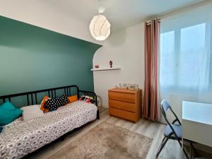 拉瓦勒Appartement et Maison Espace Mayenne的一间卧室配有一张床、一个梳妆台和一扇窗户。