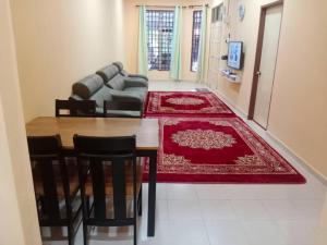 Kuala KeraiAqiza Home Kuala Krai的客厅配有桌子和沙发