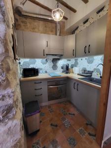 乌贝达Casa Mirador的厨房配有白色橱柜和瓷砖地板。