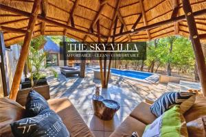 玛洛斯帕克African Sky Villas的带沙发的客厅和游泳池