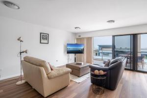Barrack PointMountain Waves的客厅配有两张沙发和一台电视机
