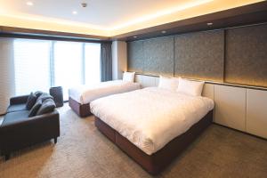 名古屋GOLD STAY Nagoya Osu的酒店客房,设有两张床和一张沙发