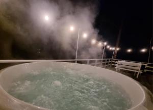 WąglikowiceSosnowy Azyl的浴缸在晚上装满水,灯光照亮