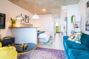 SibayaCoral Point Sibaya Luxury Apartment的客厅配有蓝色的沙发和床。