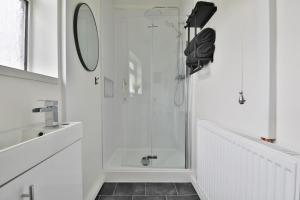 卡菲利Beautiful 3 Bedroom Home Renovated- Welsh Mountains & Hiking Trails的白色的浴室设有玻璃门淋浴