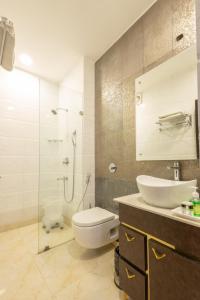 新德里Hotel Cosmo Near BLK Hospital Karol Bagh的浴室配有卫生间、盥洗盆和淋浴。