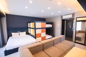 名古屋GOLD STAY Nagoya Osu的一间卧室配有一张床和一个沙发