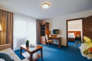 巴特法兴格Hotel Reindl Suiten & Appartments的酒店客房设有沙发、书桌和一间卧室。