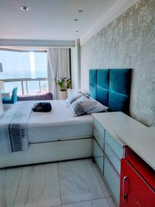 维拉维尔哈RICARDO Pousada - SUITE MASTER的一间卧室配有一张大床和蓝色床头板