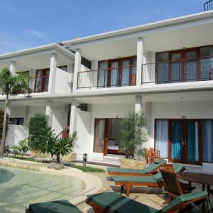 吉利阿尔De Padma Gili Air的一座带游泳池和椅子的大型白色房屋