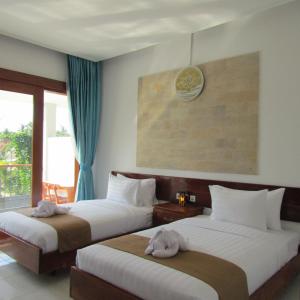 吉利阿尔De Padma Gili Air的配有窗户的酒店客房内的两张床