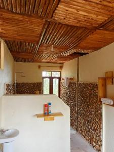 BuhomaBwindi Neckview Lodge的浴室配有水槽和木墙