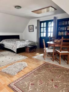 SomlóvásárhelySomlo Wineshop Guesthouse的卧室配有一张床和一张桌子及椅子
