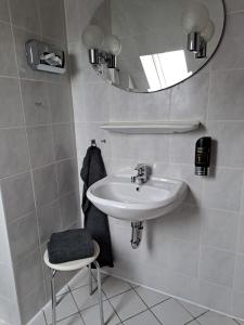 SatowPension 3 Ferienhof Hanstorf的一间带水槽、镜子和凳子的浴室