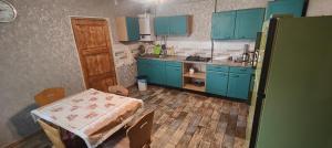 ArrinjVilla singola的厨房配有蓝色橱柜、桌子和桌椅