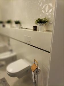 华沙Kwatera Paprotka 23的白色的浴室设有卫生间和水槽。