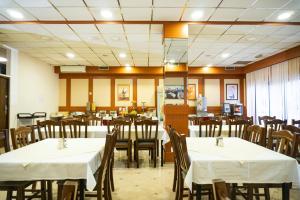 萨格勒布欧罗巴酒店的餐厅配有桌椅和白色桌布