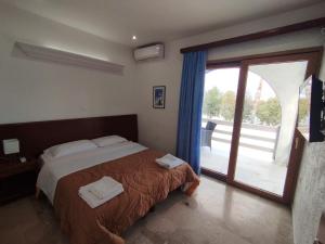 塞利亚尼蒂卡ResidenceTheo的一间卧室设有一张床和一个滑动玻璃门