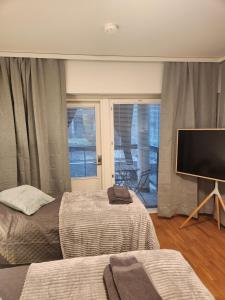 图尔库Viihtyisä täysin kalustettu ja varustettu yksiö Logomolla 1vrk-36kk的一间卧室配有两张床和一台平面电视