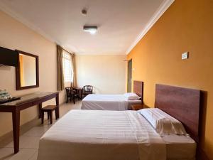 金马士Tropicana Hotel的酒店客房配有两张床和一张书桌
