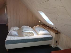 朗波普卢阿尔泽Chez Fanch的一张带四个枕头的床,上面有灯