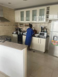 罗安达Sunny Luanda的站在厨房准备食物的人