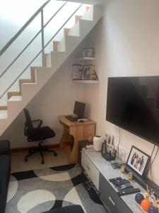 罗安达Sunny Luanda的客房设有一张带电脑和楼梯的书桌