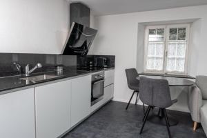 格拉鲁斯Kirchweg 22 8750 Glarus的厨房配有白色橱柜和桌椅