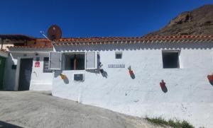 克鲁兹·德·特赫达Casa Rural LOS PINARES El Juncal de TEJEDA的白色的建筑,旁边标有标志