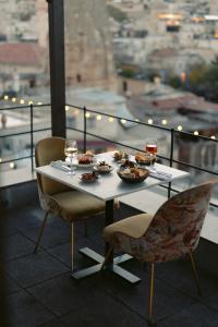 格雷梅Carus Cappadocia的餐桌,带食物盘和酒杯