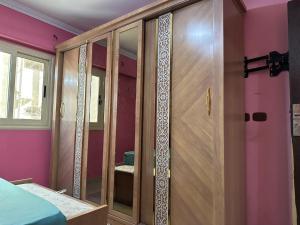 开罗Palace Luxury Rooms的卧室配有带玻璃门的木制衣柜