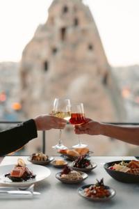 格雷梅Carus Cappadocia的两人把酒杯放在桌子上,带食物