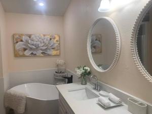 奥兰多Friendly House的浴室设有白色水槽和两面镜子